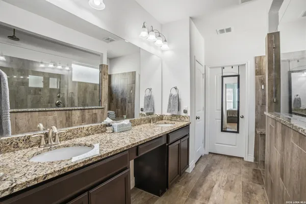 a bathroom with a granite countertop sink and a mirror