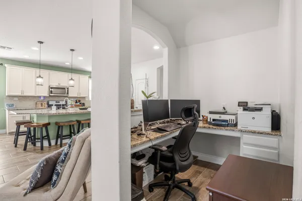 a kitchen with a table chairs a barbeque appliances and cabinets