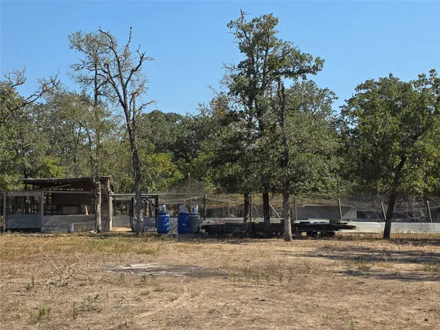 a view of house with yard and trees in the background