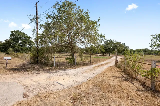 a view of a yard with wooden fence