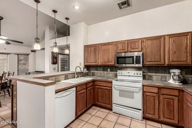 a kitchen with stainless steel appliances granite countertop a sink a stove and cabinets