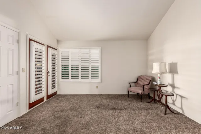 a view of a livingroom with lounge chair and a window