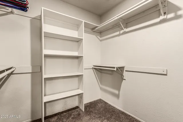 a view of walk in closet with empty racks