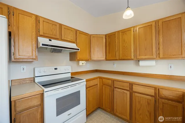 a kitchen with stainless steel appliances granite countertop a sink a stove and cabinets