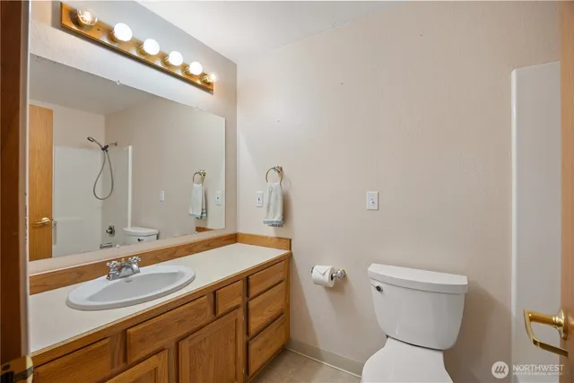 a bathroom with a sink and mirror with toilet
