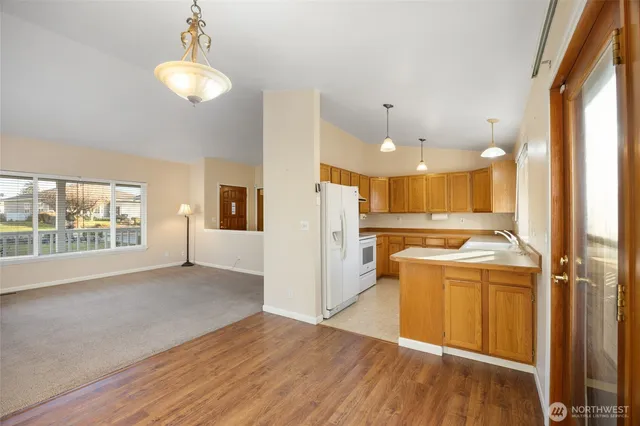 a view of a kitchen with a stove wooden cabinets and a large window