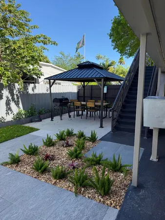 a view of a patio with a table and chairs under an umbrella