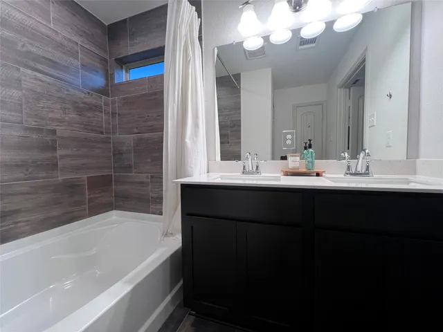 a bathroom with a sink a large mirror and a bathtub