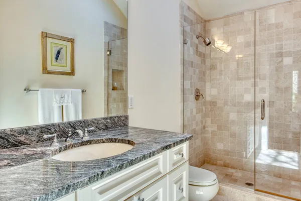 a bathroom with a granite countertop sink toilet and shower
