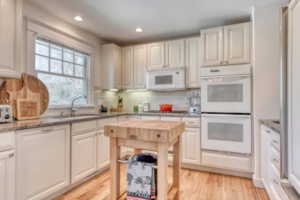 a kitchen with white cabinets and white appliances