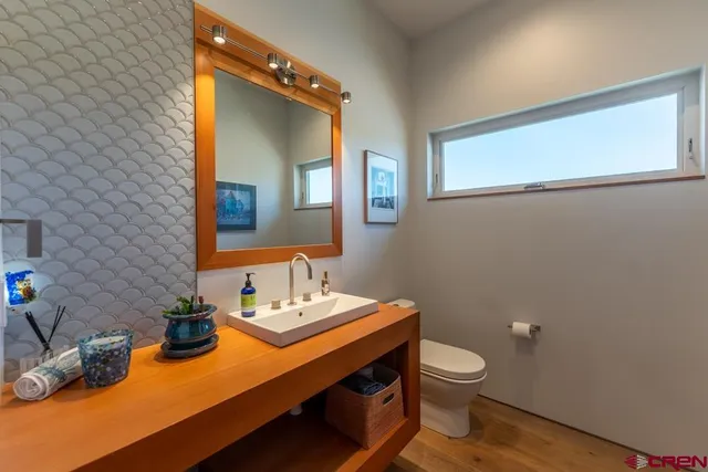 a bathroom with a toilet a sink and mirror