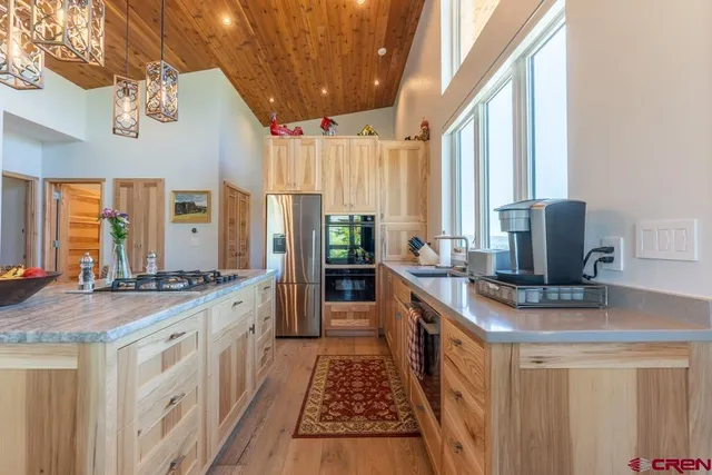 a kitchen with stainless steel appliances granite countertop a stove a sink dishwasher and a refrigerator