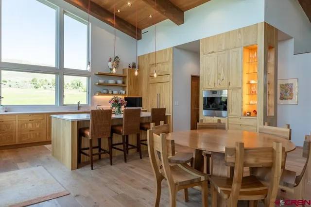 a dining hall with stainless steel appliances a dining table and chairs