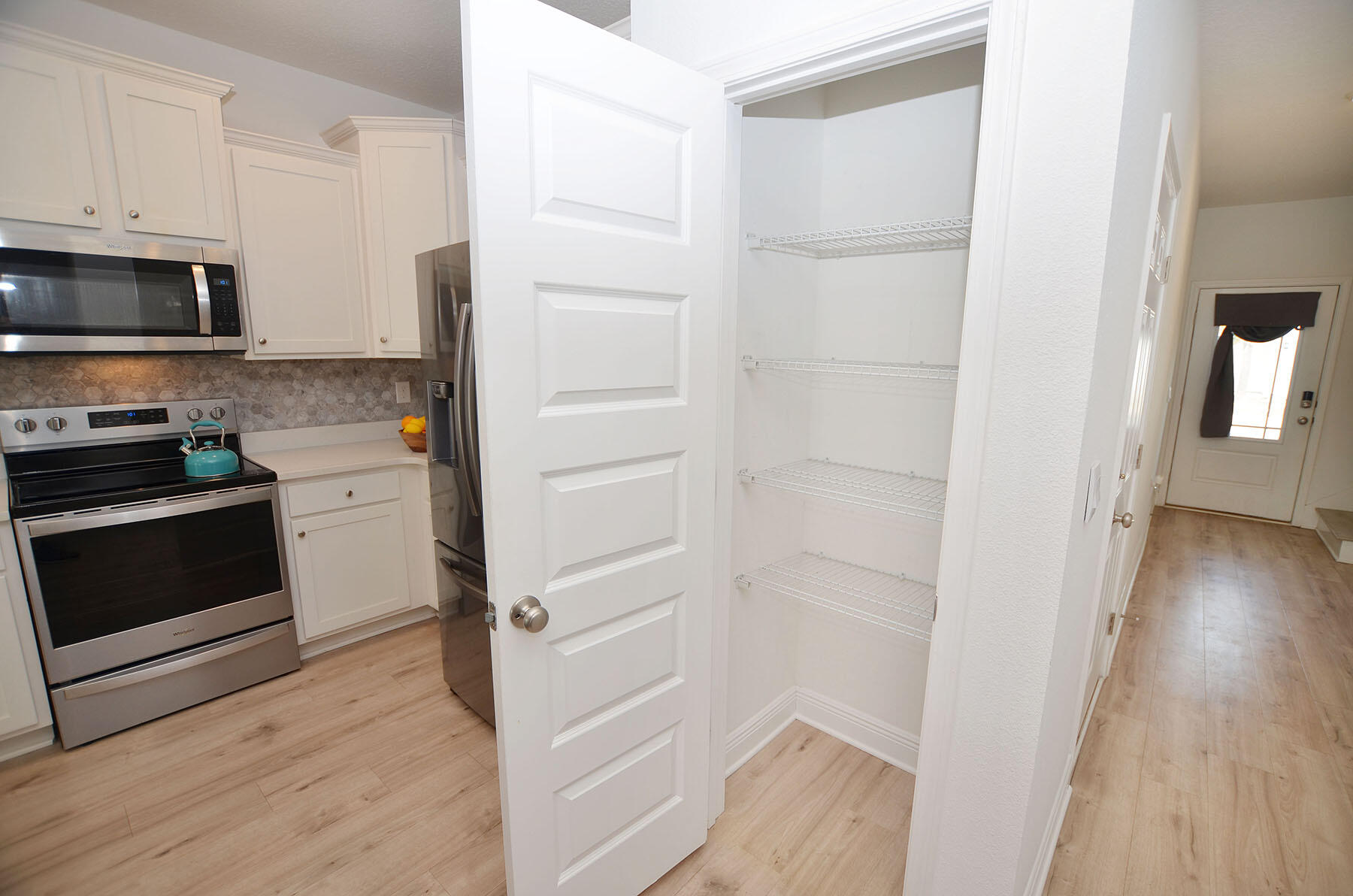 16 Redbird Loop Destin, FL 32541 - Photo 16 of 56 a kitchen with white cabinets and stainless steel appliances