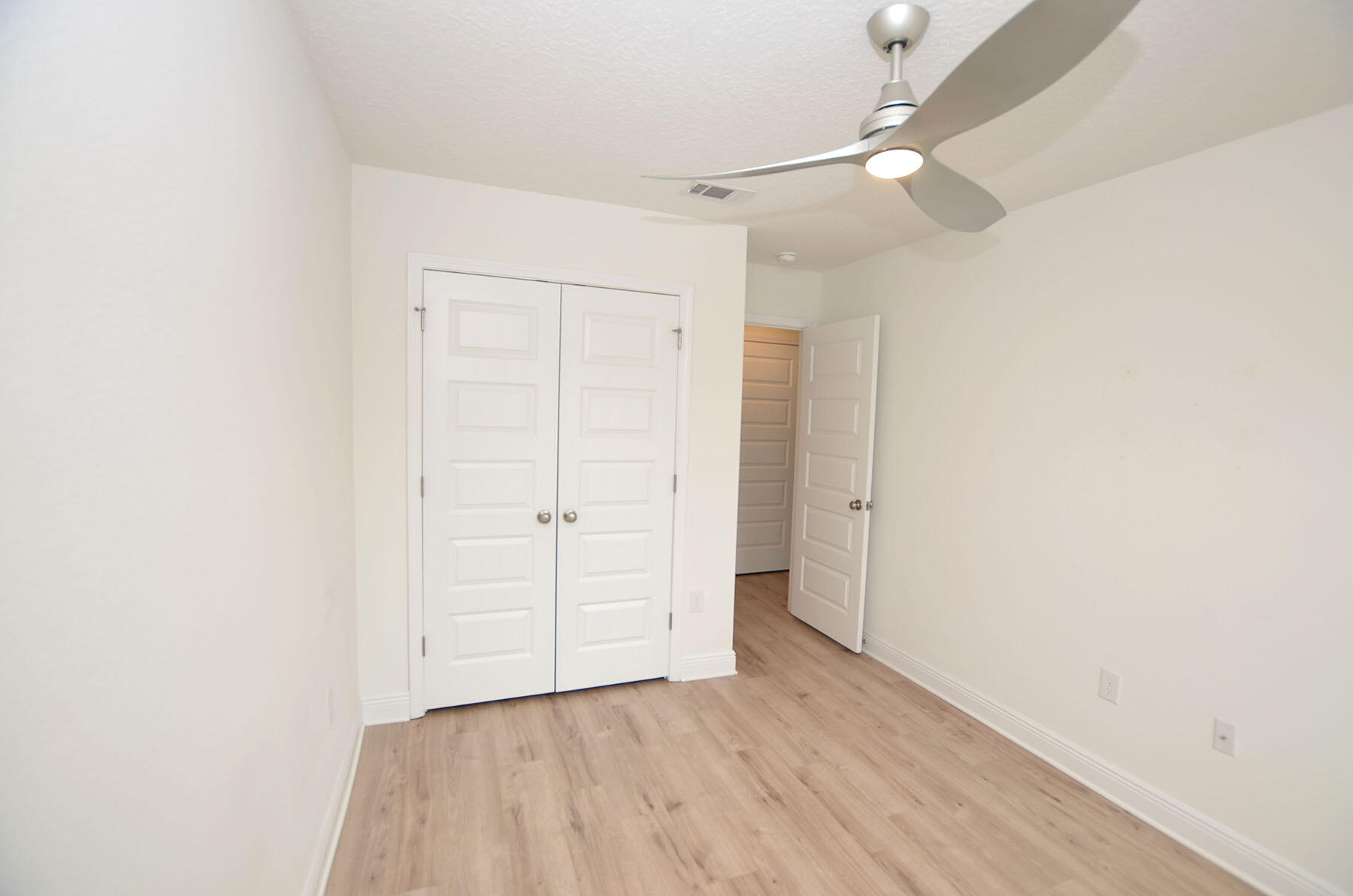 16 Redbird Loop Destin, FL 32541 - Photo 40 of 56 an empty room with a ceiling fan and wooden floor