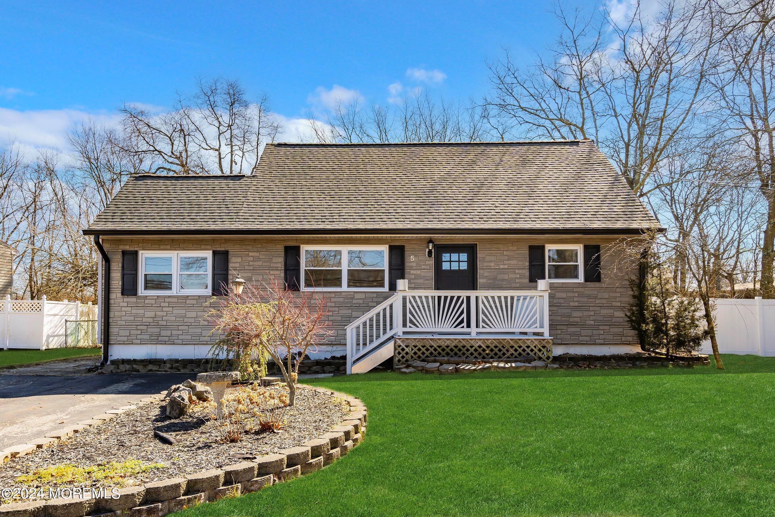 a front view of a house with a garden and yard