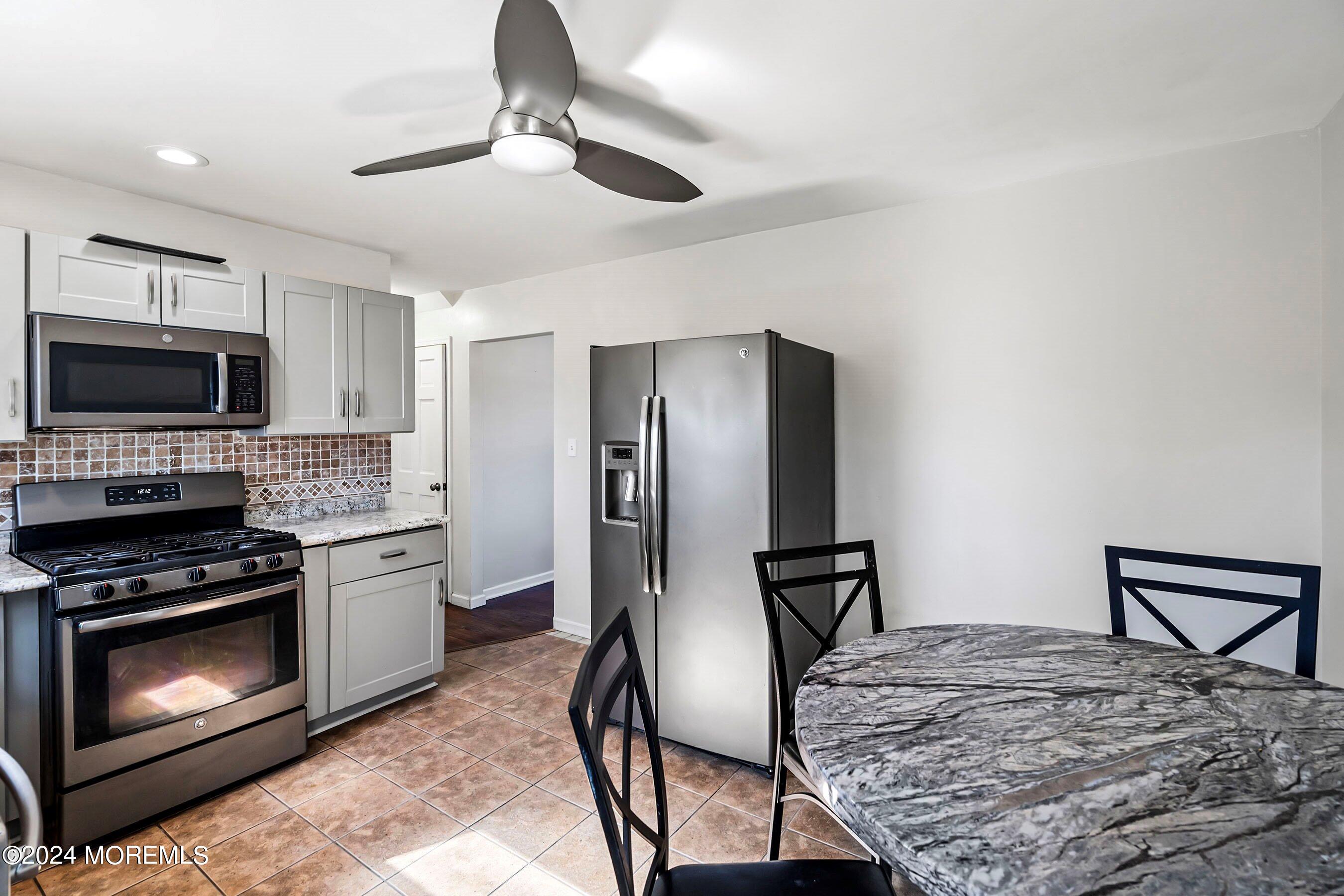 5 Hampton Road Howell, NJ 07731 - Photo 11 of 27 a kitchen with stainless steel appliances granite countertop a stove refrigerator and microwave