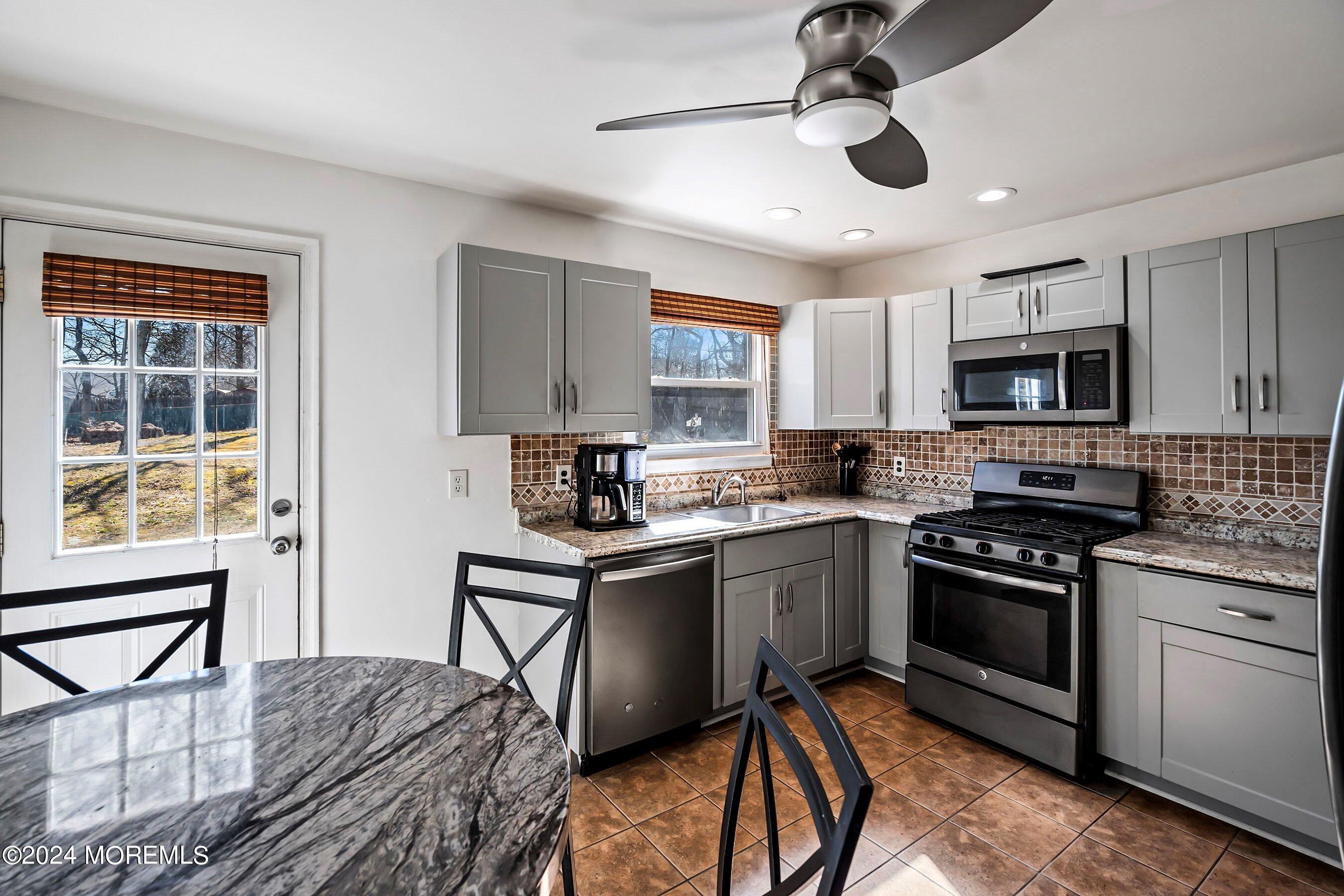 5 Hampton Road Howell, NJ 07731 - Photo 13 of 27 a kitchen with stainless steel appliances granite countertop a stove sink microwave and cabinets