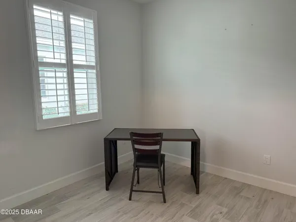 a view of a workspace with wooden floor and a window