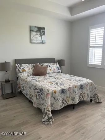 a bedroom with a bed and wooden floor