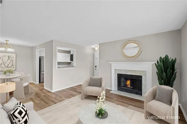 a living room with furniture a potted plant and a large window