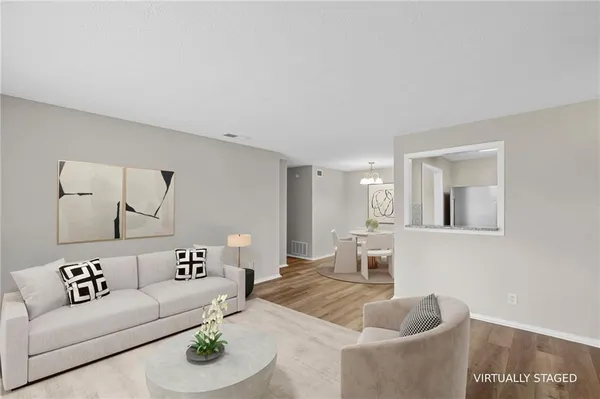 a kitchen with stainless steel appliances granite countertop white cabinets a sink a stove a microwave and wooden floors