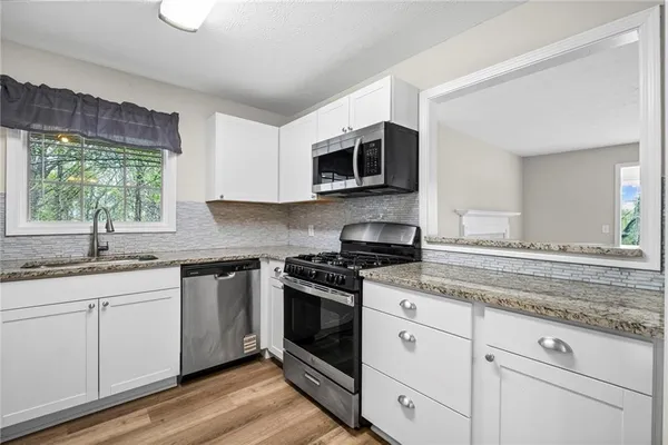 a view of a room with wooden floor and chandelier