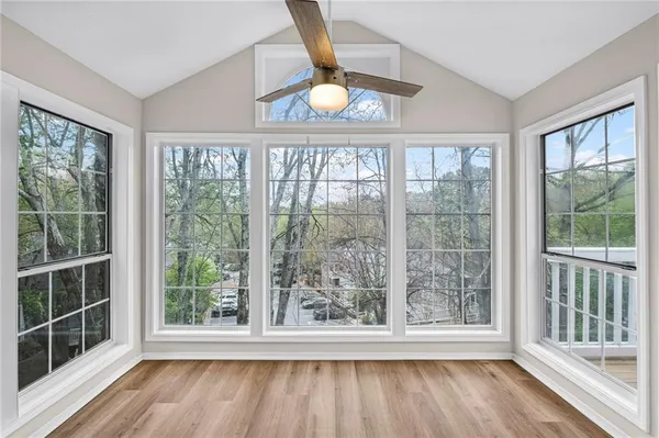 a view of an empty room with wooden floor and a window
