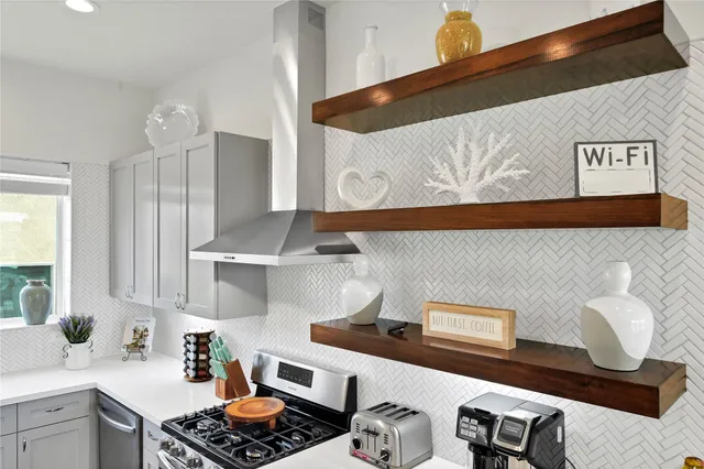a kitchen with stainless steel appliances granite countertop a sink stove and white cabinets