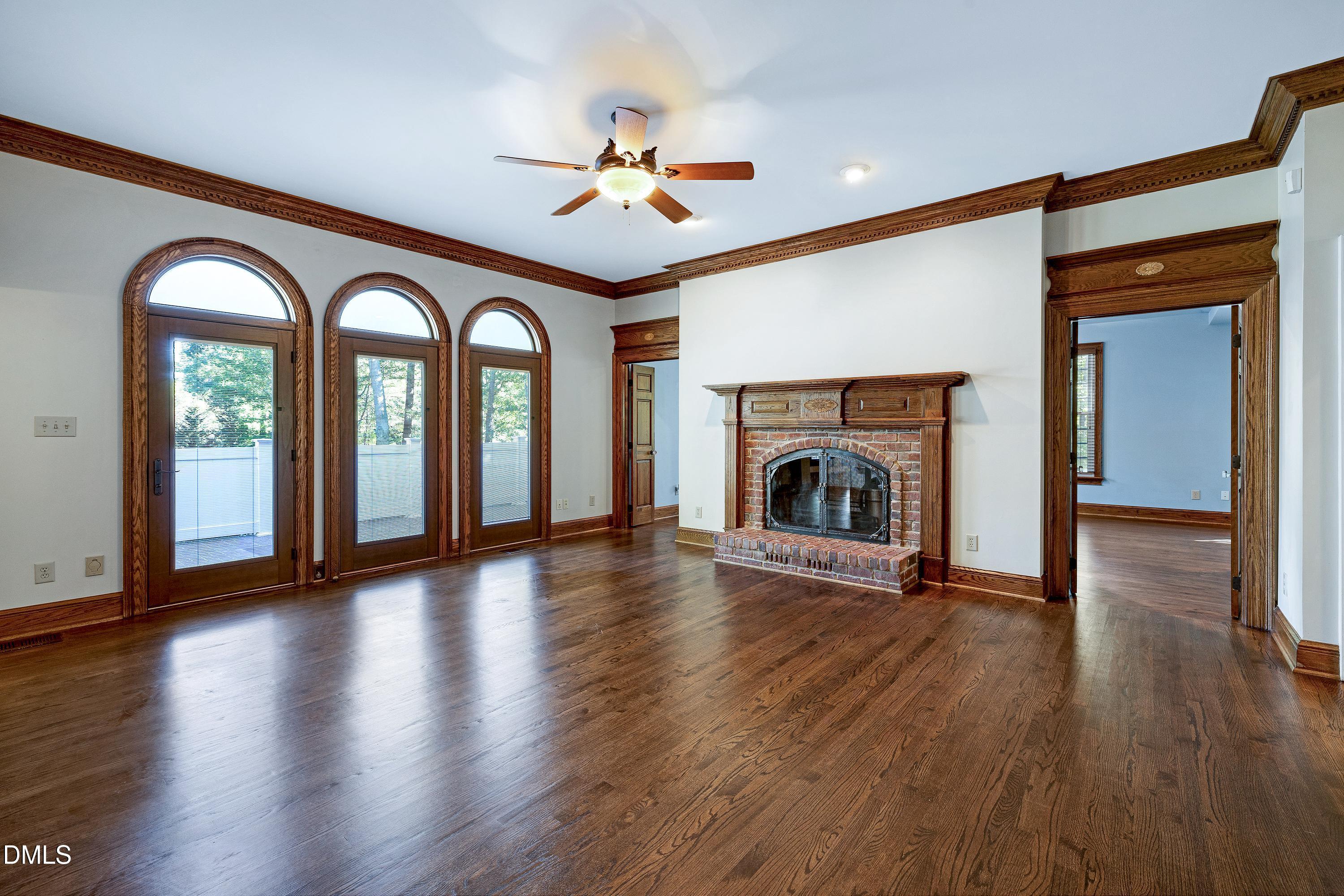 6825 Mactavish Way Raleigh, NC 27613 - Photo 17 of 100 a view of an empty room with a fireplace and wooden floor