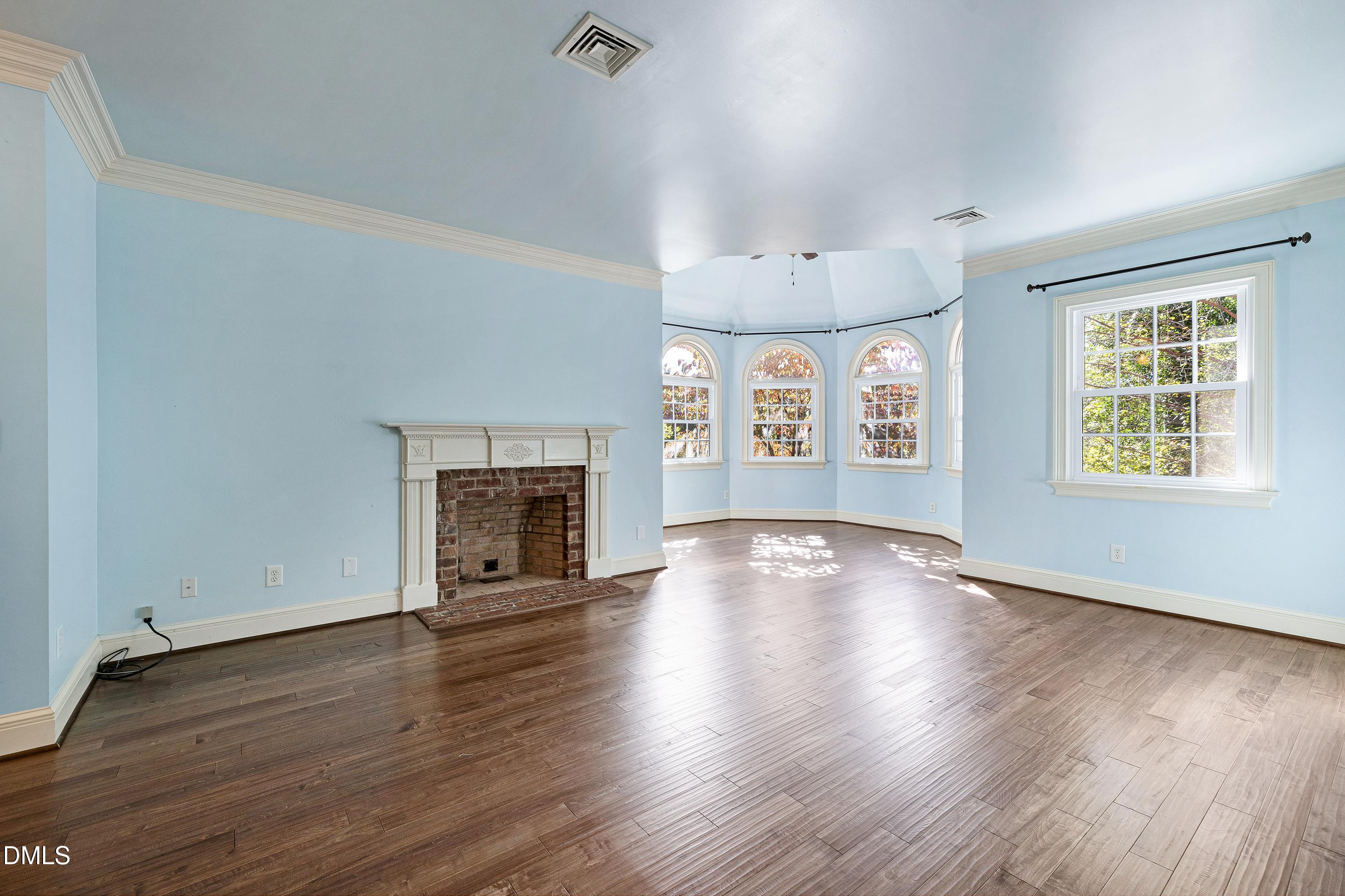 6825 Mactavish Way Raleigh, NC 27613 - Photo 34 of 100 an empty room with wooden floor fireplace and windows