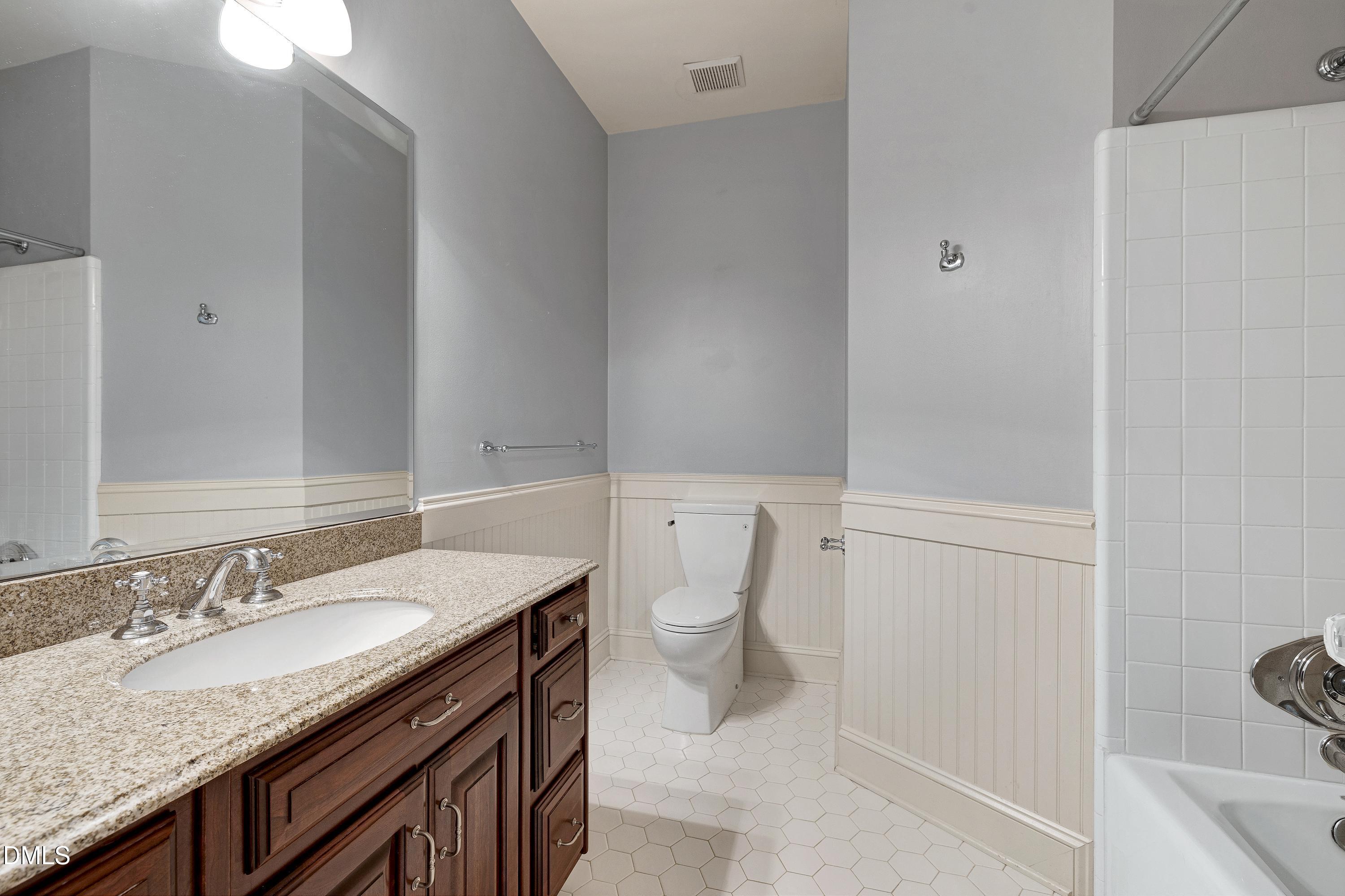 6825 Mactavish Way Raleigh, NC 27613 - Photo 39 of 100 a bathroom with a granite countertop sink a toilet and bathtub