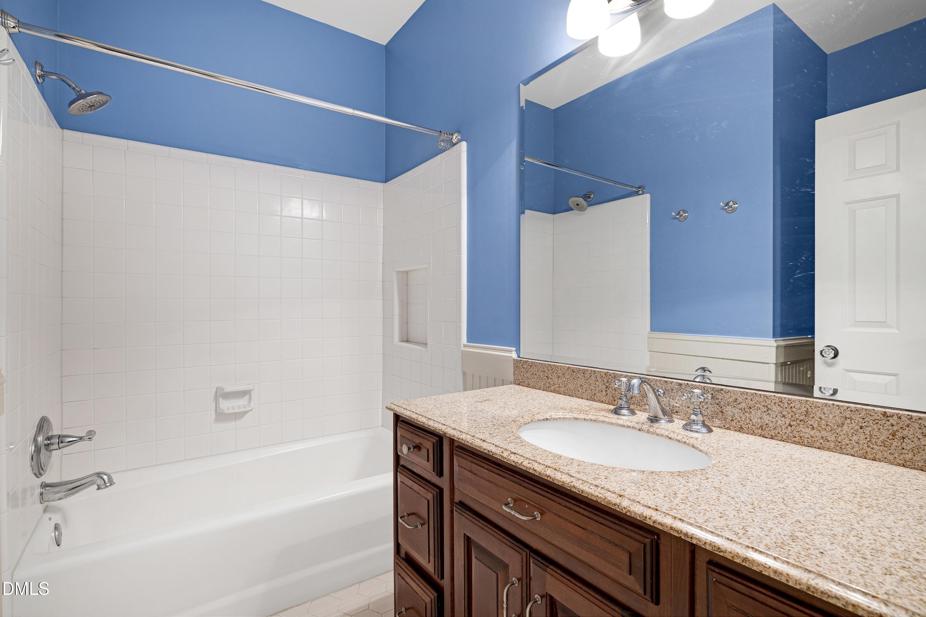 6825 Mactavish Way Raleigh, NC 27613 - Photo 42 of 100 a bathroom with a granite countertop sink and a mirror