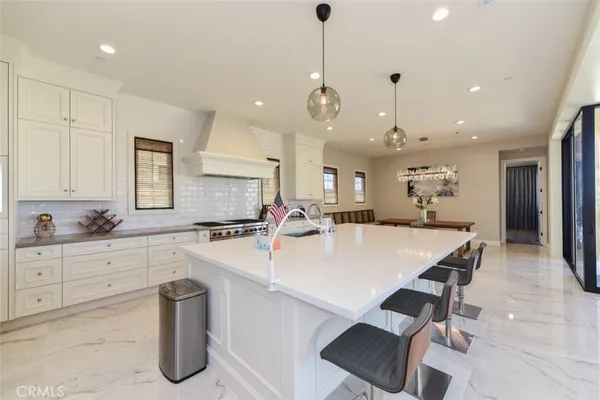 a large kitchen with kitchen island a sink table and chairs