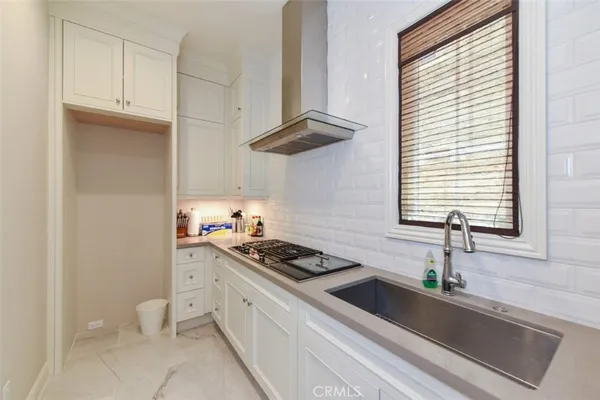 a kitchen with stainless steel appliances a sink a stove and white cabinets