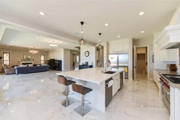 a large kitchen with stainless steel appliances a stove a sink a oven a dining table and chairs