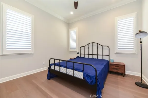 a bedroom with a bed window and a night stand on it