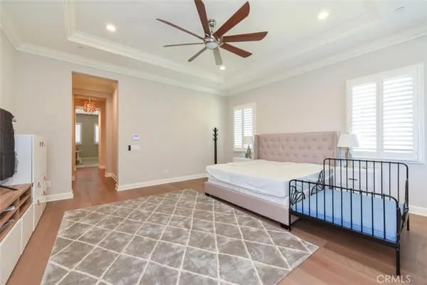 a spacious bedroom with a bed and a flat screen tv