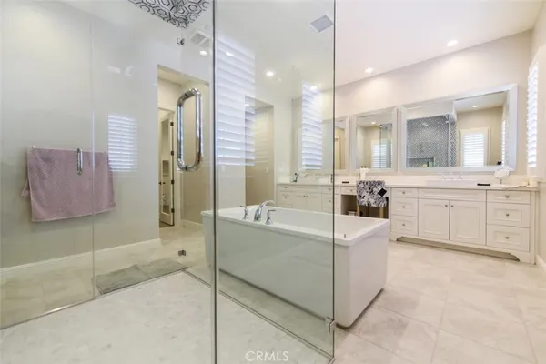a spacious bathroom with a tub sink and mirror