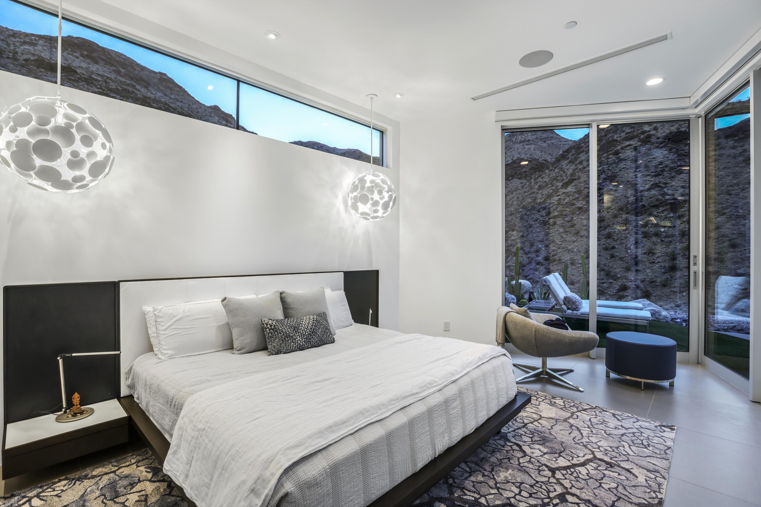 1747 Pinnacle Point Palm Springs, CA 92264 - Photo 31 of 76 a bedroom with a bed a table and glass window