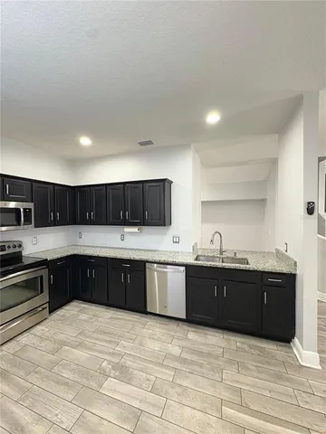 a kitchen with stainless steel appliances granite countertop a sink and cabinets