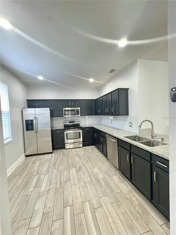 a large kitchen with stainless steel appliances granite countertop a stove and a sink