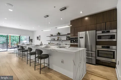 a kitchen with kitchen island a sink stove and refrigerator