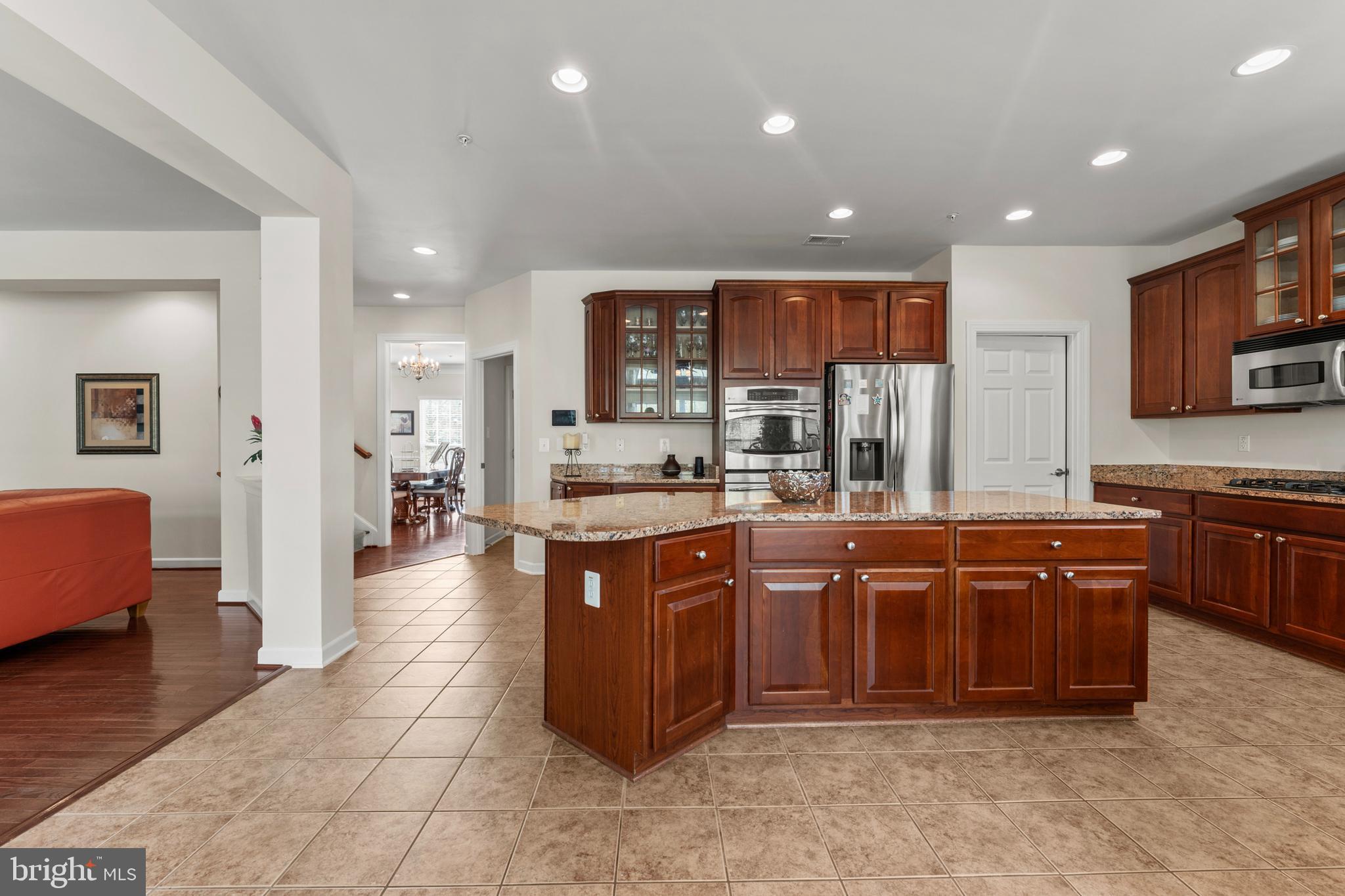 10916 Sir Paul Place Clinton, MD 20735 - Photo 28 of 66 a large kitchen with stainless steel appliances granite countertop a large stove a sink and a refrigerator