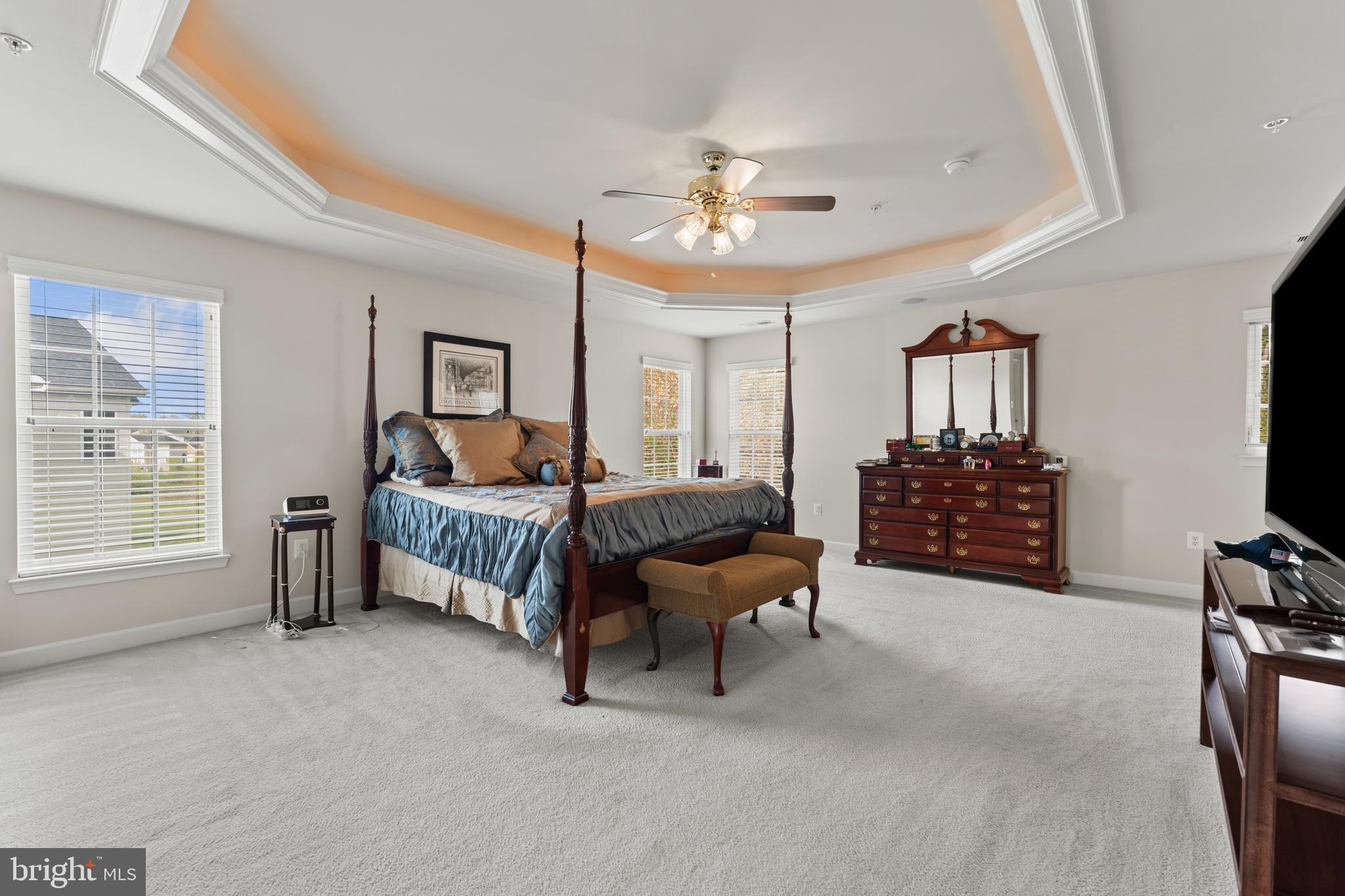 10916 Sir Paul Place Clinton, MD 20735 - Photo 38 of 66 a spacious bedroom with a bed a dresser and a flat screen tv