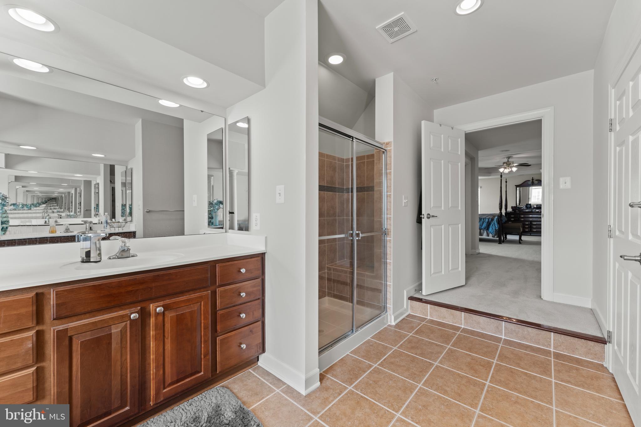 10916 Sir Paul Place Clinton, MD 20735 - Photo 41 of 66 a spacious bathroom with a double vanity sink a mirror and a shower