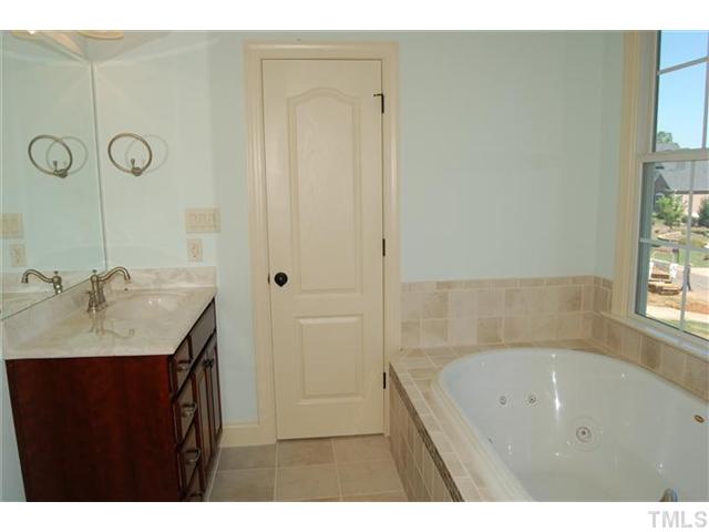294 High Ridge Lane Pittsboro, NC 27312 - Photo 8 of 11 a bathroom with a granite countertop sink a mirror and a bathtub