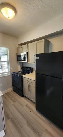 a kitchen with a refrigerator and a stove