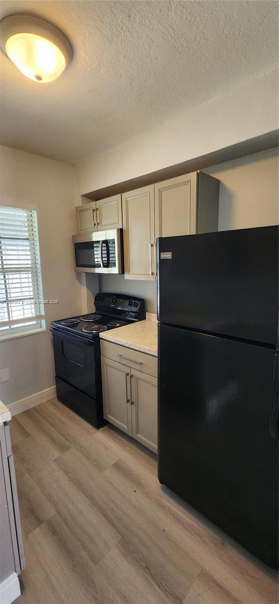 405 Northwest 64th Street Miami, FL 33150 - Photo 26 of 28 a kitchen with a refrigerator and a stove