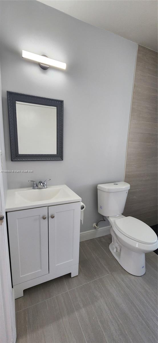 405 Northwest 64th Street Miami, FL 33150 - Photo 27 of 28 a bathroom with a toilet sink and mirror